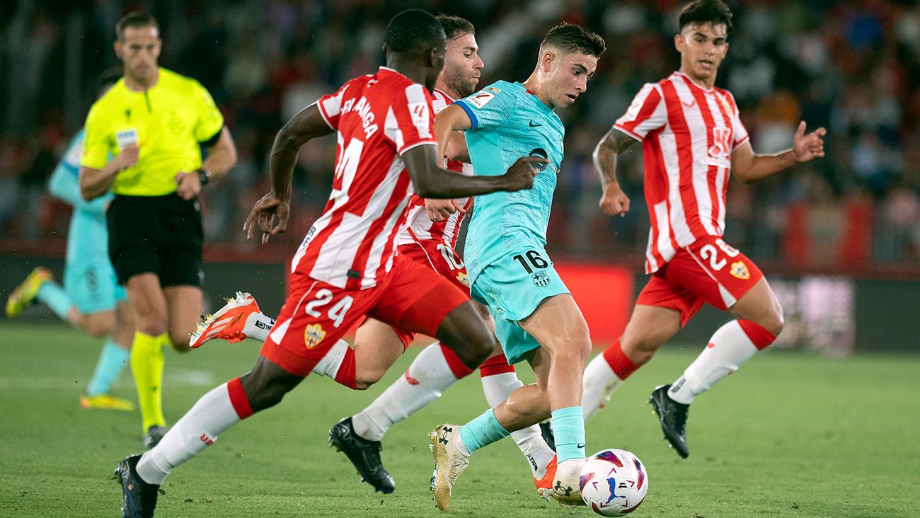 Fermín López conduce con jugadores del Almería alrededor