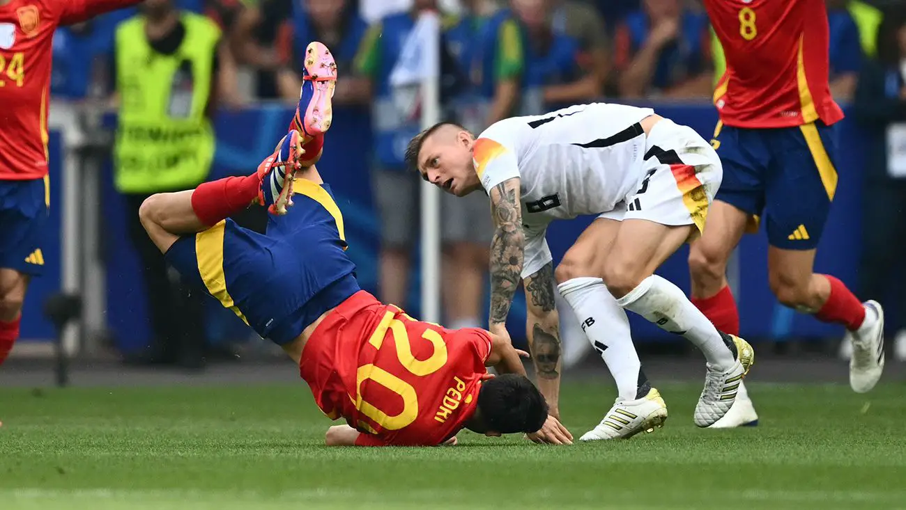 Pedri y Kroos chocando en un partido