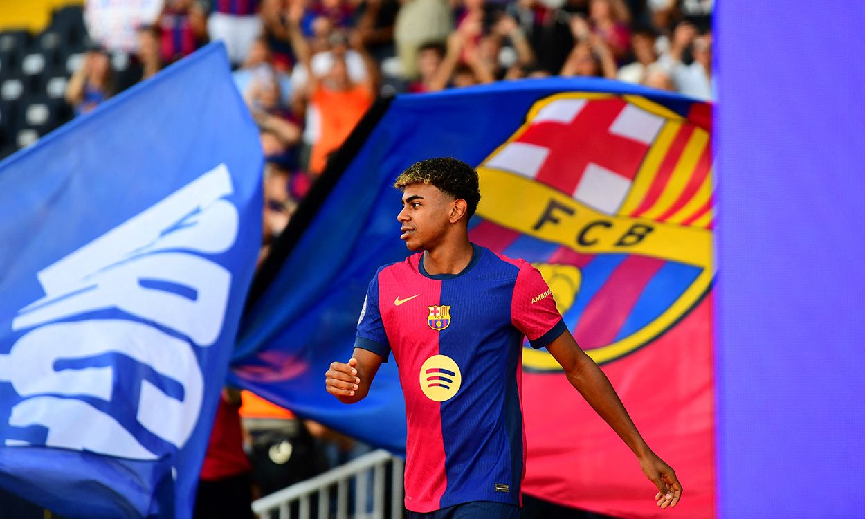 Lamine Yamal con el escudo del Barça de fondo