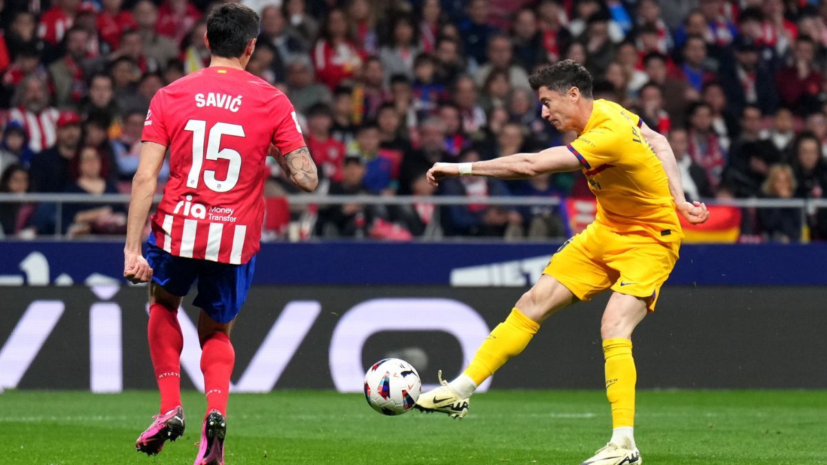 Robert Lewandowski chutando a portería ante la presencia de Stefan Savic en un Atlético-Barça